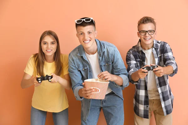 Adolescenti che giocano al videogioco su sfondo a colori — Foto Stock