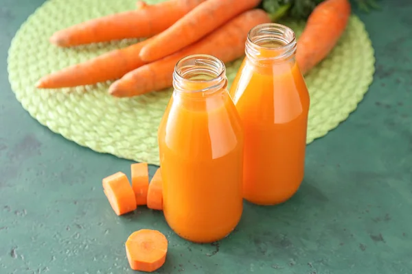 Bottles of tasty carrot juice on table — Stock Photo, Image