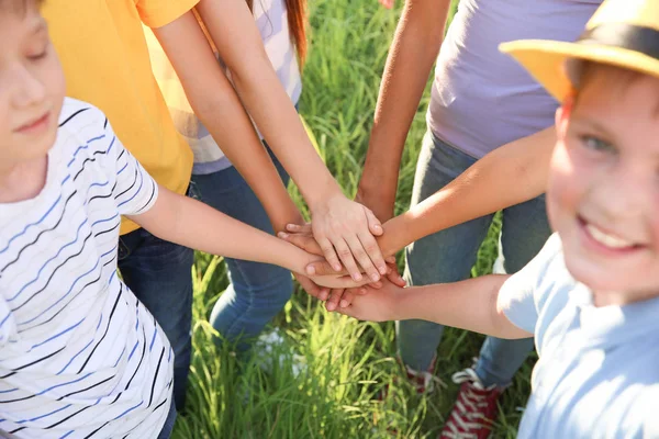 Groupe d'enfants mettant les mains ensemble à l'extérieur — Photo