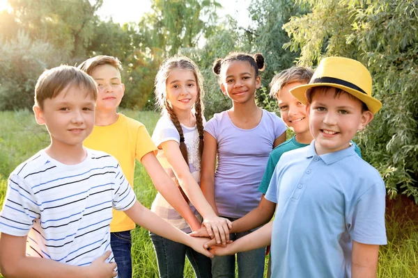 Group of children putting hands together outdoors — Stock Photo, Image