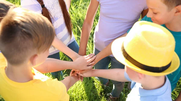 Grupp barn som sätter händer tillsammans utomhus — Stockfoto