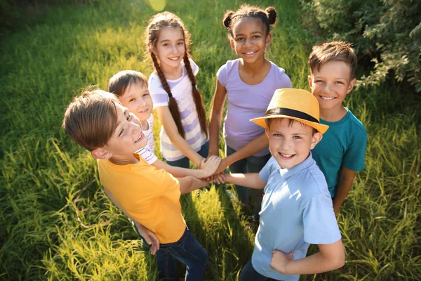 Group of children putting hands together outdoors — Stock Photo, Image