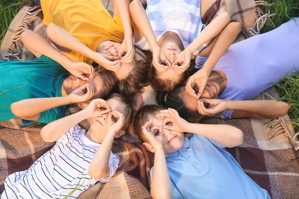 Kindergruppe liegt auf Plaid im Park — Stockfoto