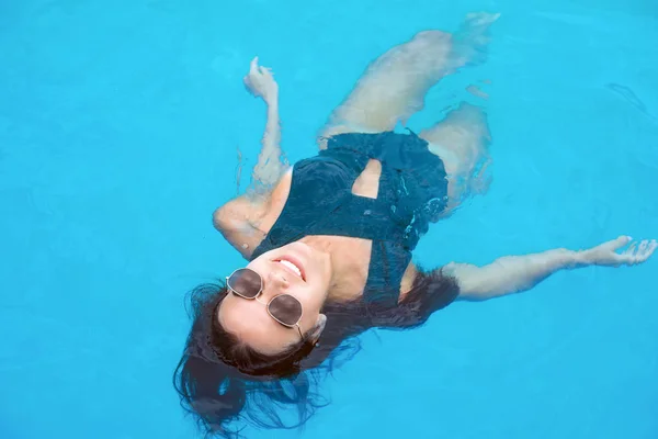 Belle jeune femme nageant dans la piscine — Photo