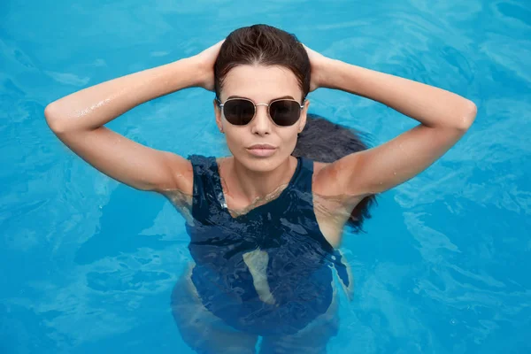 Красива молода жінка плаває в басейні — стокове фото
