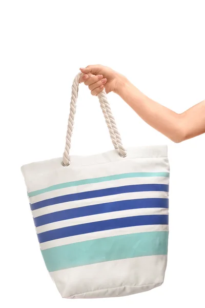 Женская рука со стильной пляжной сумкой на белом фоне — стоковое фото