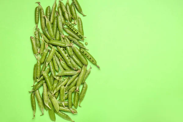 Leckere frische Erbsen auf farbigem Hintergrund — Stockfoto