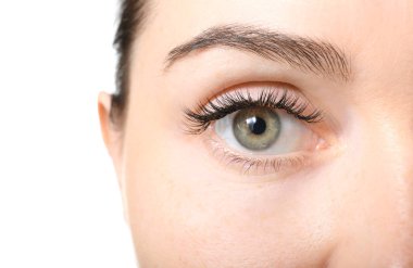 Beyaz arka planda kirpik uzantıları olan güzel bir genç kadın, yakın plan.