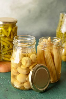 Renkli masada konserve mısır ve mantar ile Kavanozlar