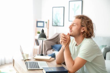 Dindar genç adam evde dua ediyor