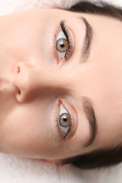 Wanita muda menjalani prosedur ekstensi bulu mata di salon kecantikan, closeup — Stok Foto