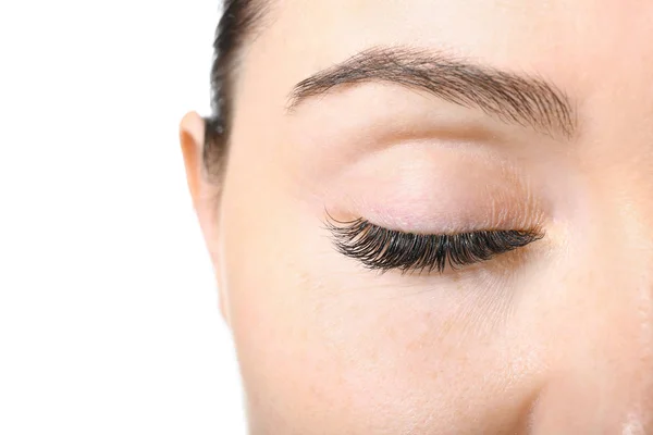 Beautiful young woman with eyelash extensions on white background, closeup — Stock Photo, Image