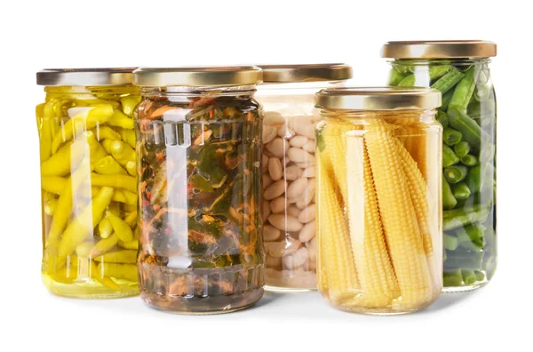 Frascos con diferentes verduras y legumbres enlatadas sobre fondo blanco — Foto de Stock