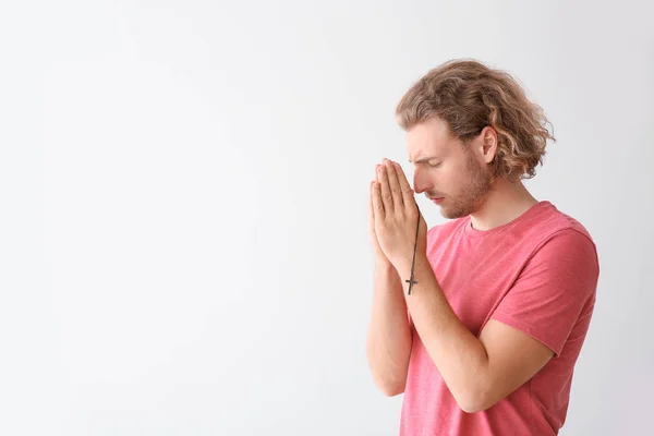 Религиозный юноша молится на белом фоне — стоковое фото