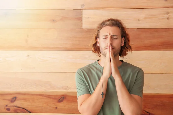 Religiös ung man ber på trä bakgrund — Stockfoto