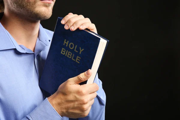 Jovem religioso orando em fundo escuro, close-up — Fotografia de Stock