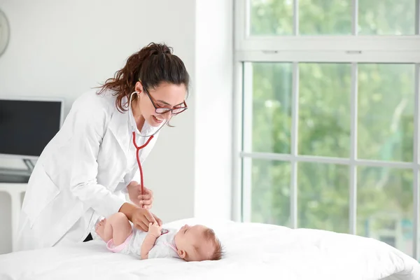 Pediatra examinando pequeño bebé en clínica — Foto de Stock