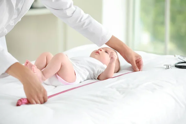 Pediatra examinando pequeño bebé en clínica — Foto de Stock