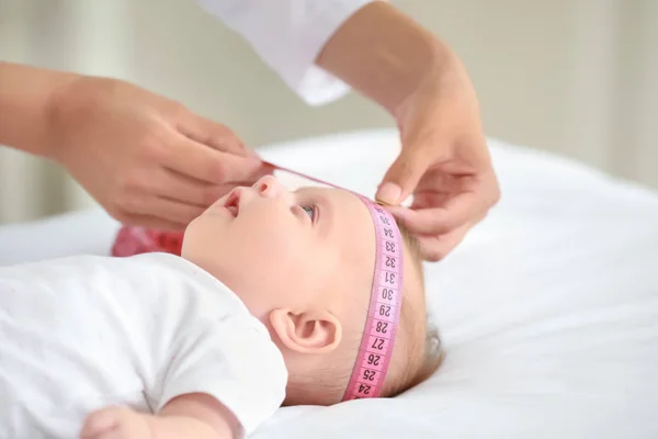 Pediatra examinando pequeño bebé en clínica —  Fotos de Stock