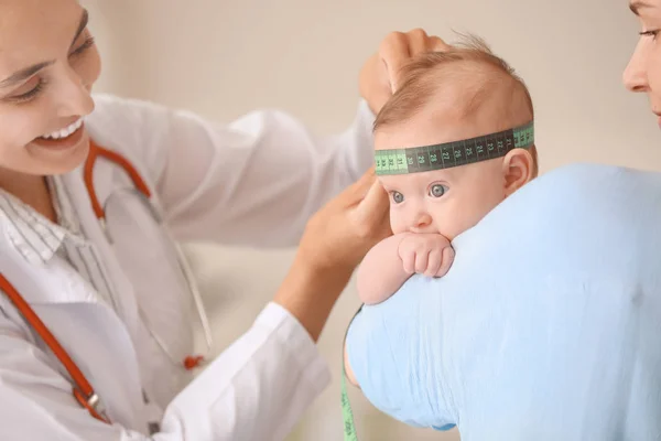 Pediatra examinando pequeño bebé en clínica — Foto de Stock