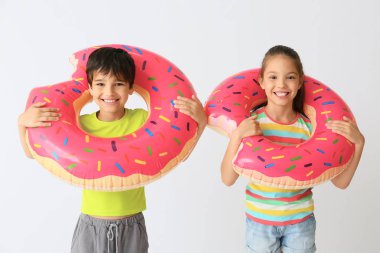 Hafif arka planda şişme halkaları ile Sevimli küçük çocuklar