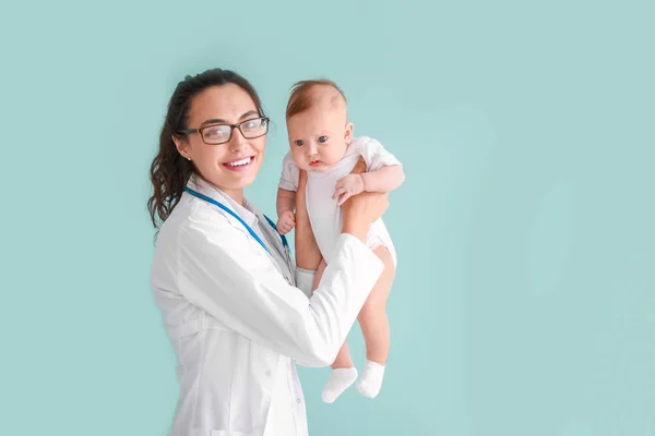 Pediatrician with cute little baby on color background — Stock Photo, Image