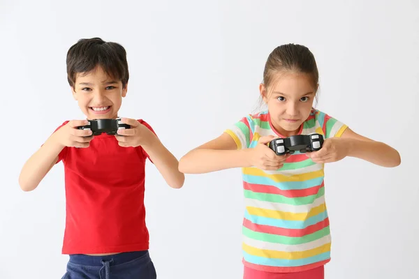 Enfants émotionnels jouant à des jeux vidéo sur fond de lumière — Photo