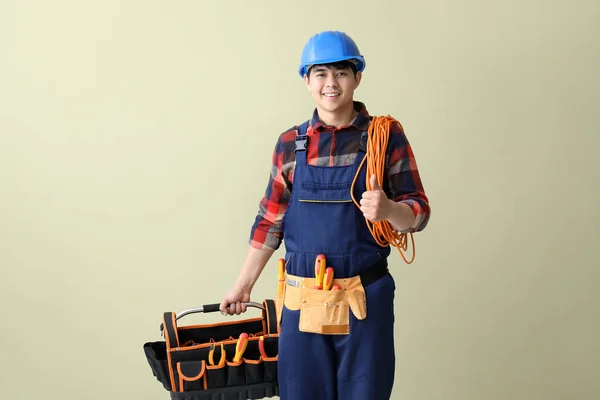 Electricista masculino con herramientas sobre fondo de color — Foto de Stock