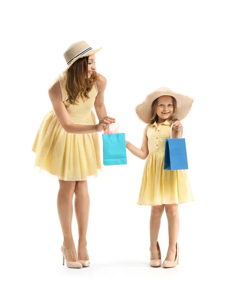 Portrait of beautiful woman and her little daughter with shopping bags on white background — Stock Photo, Image