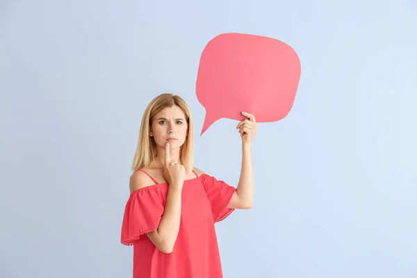 Thoughtful woman with speech bubble on color background — Stock Photo, Image