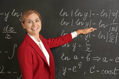 Sınıfta kara tahta yakınında güzel matematik öğretmeni