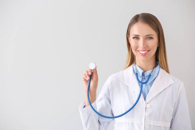 Arka planda steteskobu olan kadın doktor.