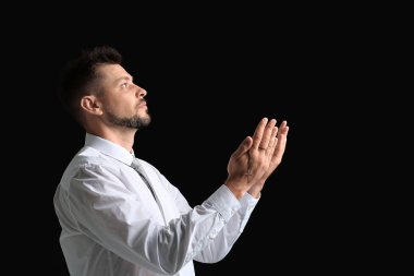 Dini adam karanlık arka plan üzerinde dua