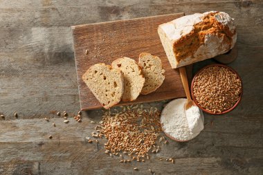 Ahşap arka planda buğday unu ve tahıllı taze ekmek