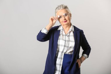 Gri arka planda şık yaşlı kadın