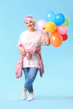 Renkli arka planda hava balonları ile şık yaşlı kadın