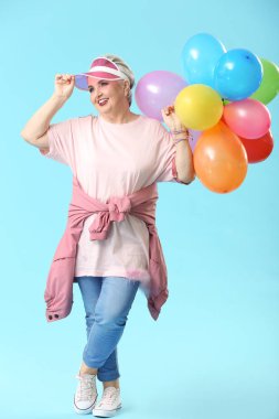 Renkli arka planda hava balonları ile şık yaşlı kadın