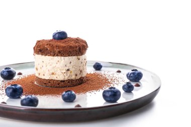 Beyaz arka planda lezzetli kek ve yaban mersini ile Tabak