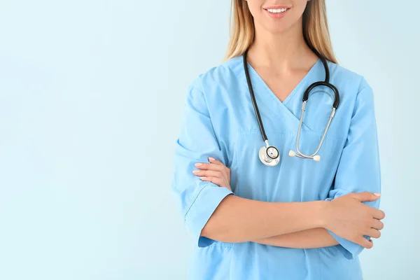 Female nurse with stethoscope on color background — Stock Photo, Image