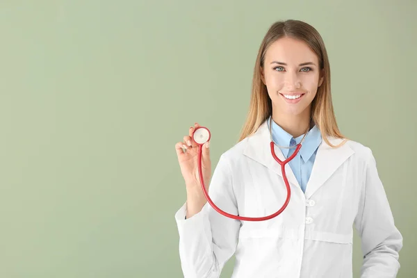 Female doctor with stethoscope on color background — Stock Photo, Image