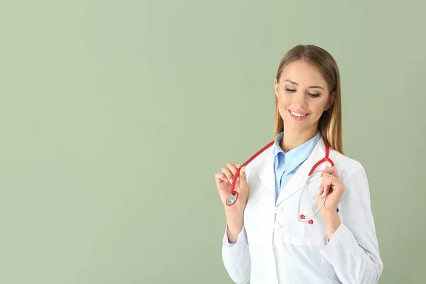 Female doctor with stethoscope on color background — Stock Photo, Image