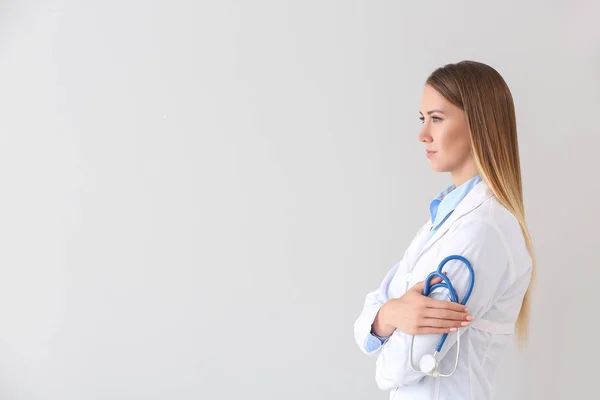 Female doctor with stethoscope on light background — Stock Photo, Image