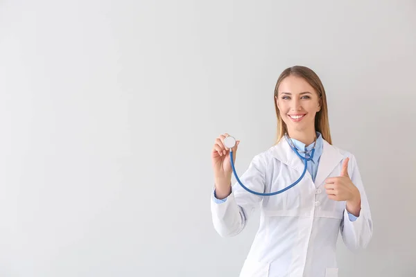 Kobieta-lekarz ze stetoskopem na jasnym tle — Zdjęcie stockowe