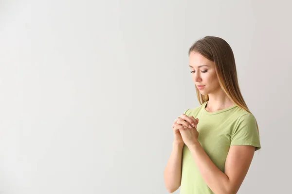 Vallásos fiatal nő imádkozik fehér háttér — Stock Fotó