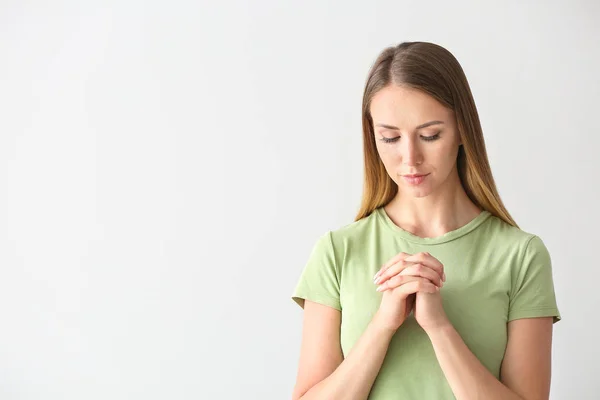 Religiosa jovem orando em fundo branco — Fotografia de Stock