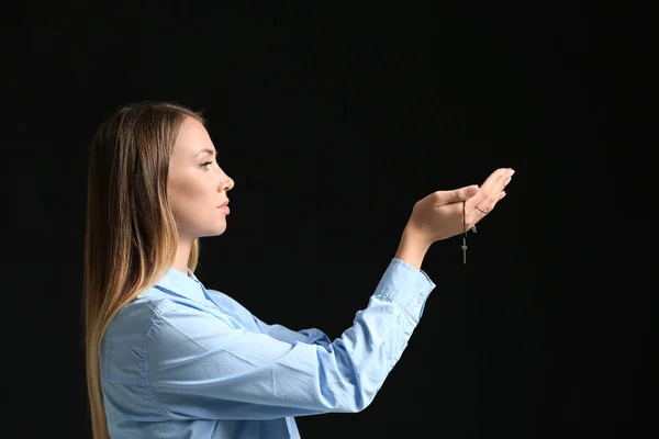 Religious young woman praying on dark background — Stock Photo, Image