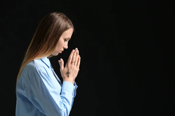 Vallási fiatal nő imádkozott a sötét háttér — Stock Fotó