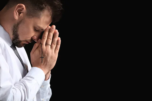 Religious man praying on dark background — Stock Photo, Image