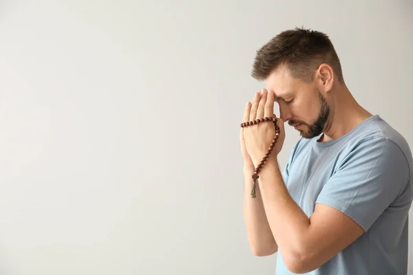 Religious man praying on light background — Stock Photo, Image