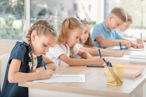 Pupils passing school test in classroom